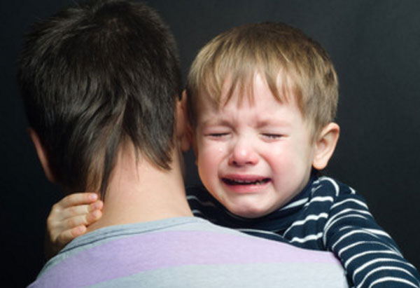 Ребенок плачет на руках у папы